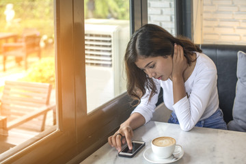 Beautiful young woman Playing Mobile with morning coffee