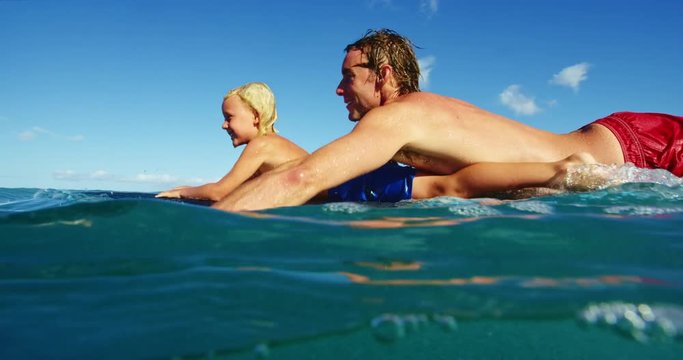 Father and son having fun surfing together, summer lifestyle family time