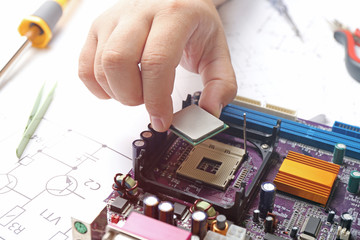 Man installing microprocessor on motherboard, close up