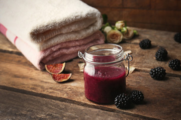 Body scrub and fruits on wooden table
