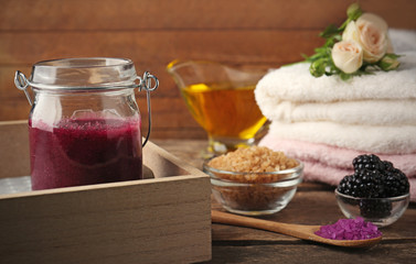 Body scrub, salt and fruits on wooden table