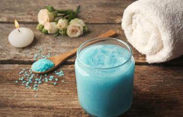 Body scrub and sea salt on wooden table