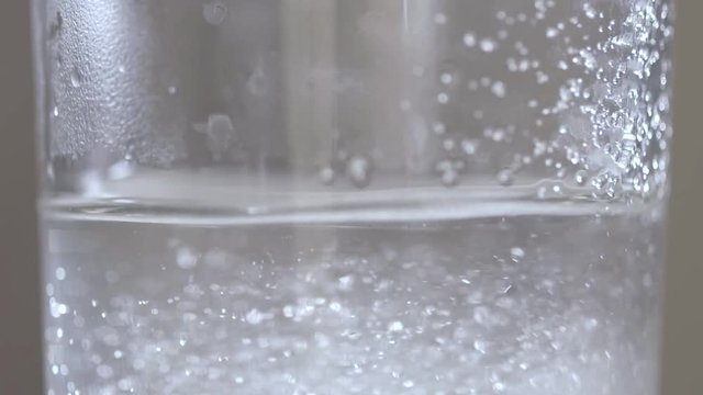 Sport supplement, creatine, hmb, bcaa, amino acid or vitamin - scoop with some powder over a glass of water. Sport nutrition or health concept.