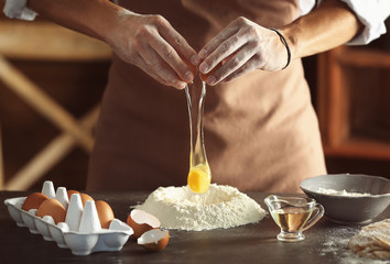 Man preparing dough on kitchen table, close up view