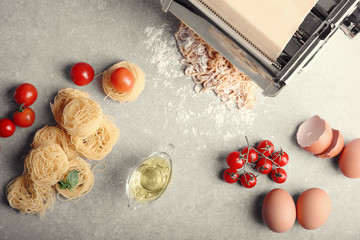 Fototapeta na wymiar Products, spaghetti and pasta machine on kitchen table