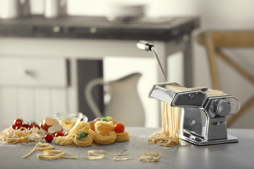 Products and word PASTA made from tagliatelle on kitchen table