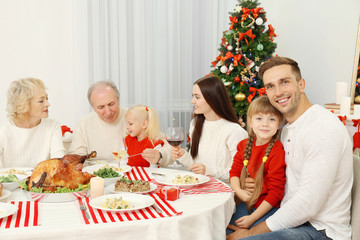 Happy family having Christmas dinner in living room