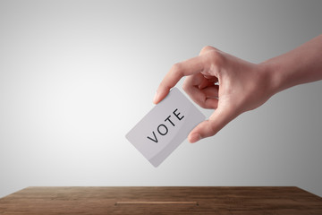 Person hand giving his vote in a ballot box