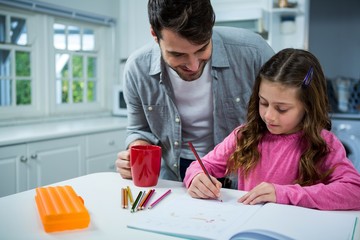 Father helping girl with homework