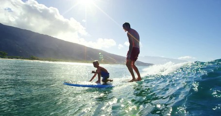 Father and son having fun surfing together, summer lifestyle family time