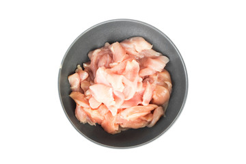 Top view pieces of raw chicken fillet in bowl on white backgroun