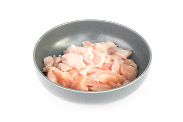 Pieces of raw chicken fillet in bowl on white background, raw ma
