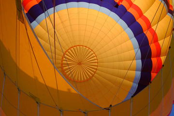 Inside of a colorful hot air balloon as it is inflated for flight.