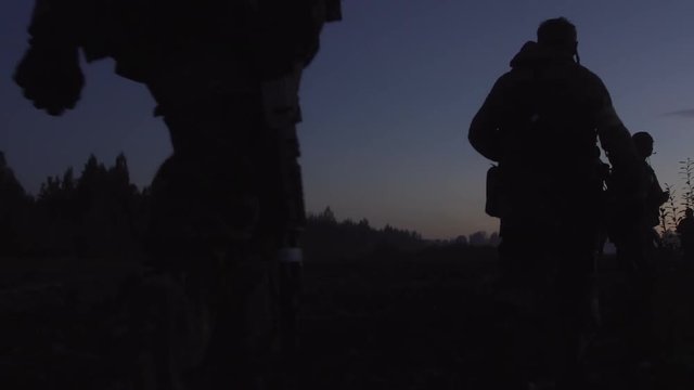 Soldiers are on the muddy field at sunset. Military night.