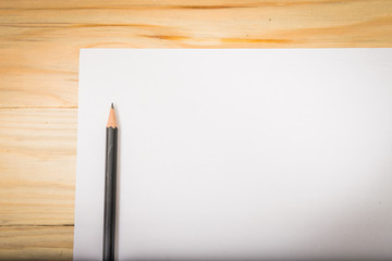 Blank paper with pencil on wood table