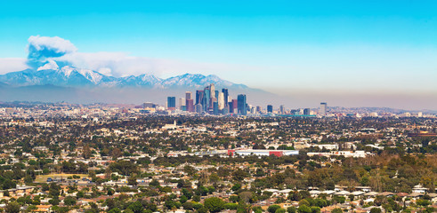 View of LA with smoke from a forest fire rising from the mountains