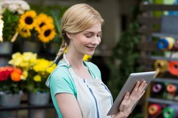 Crédence de cuisine en verre imprimé Fleuriste Female florist using digital tablet in florist shop