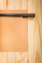 Brown note book with pen on wood background