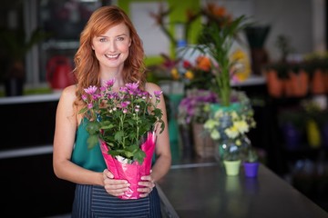 Female florist holding flower bouquet at flower shop