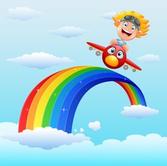 Happy little boy riding a plane in near rainbow