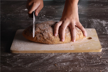cutting a bread isolated on wooden background