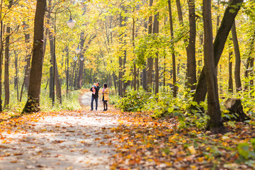 Fototapeta premium love, parenthood, family, season and people concept - smiling couple with baby in autumn park