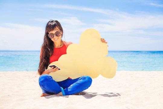 Cloud storage concept. Woman holding paper cloud icon on the bea