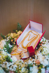 Naklejka na ściany i meble A group of gold ornament in red jewelry box. Prepare for engagement in Thai - Chinese Wedding Ceremony . Thai wedding object decorated
