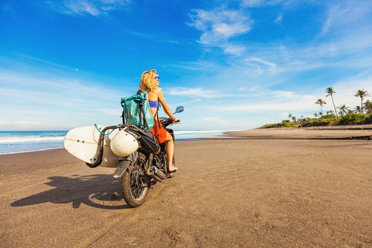 wonderful trip - woman riding a motorcycle with the surfboard