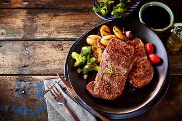 Selbstklebende Fototapeten Steak, potato and vegetable dinner on table © exclusive-design