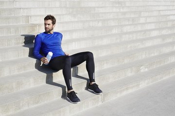 Athlete taking a break on steps, looking away