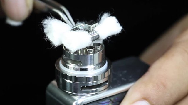 wicking organic cotton in new dual kanthal micro coils to atomizer’s deck base of electronic cigarette for vaping, close up scene, high definition, Full HD, 1920x1080