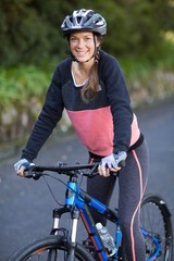 Naklejka premium Female biker with mountain bike in countryside