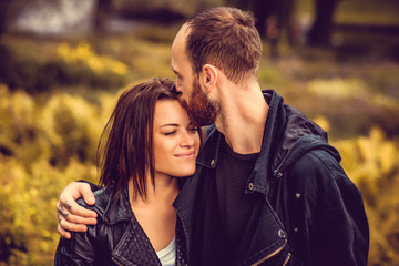 Fototapeta premium Bearded male kissing cute happy female in a head.