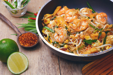 Famous traditional thai food shrimp pad thai, rice noodle stir-fry with prawns, tofu and vegetables on cooking pan.