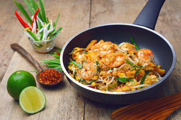 Famous traditional thai food shrimp pad thai, rice noodle stir-fry with prawns, tofu and vegetables on cooking pan. © mamsizz