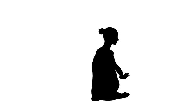 Young woman meditating in yoga pose silhouette. White. Slow motion. Silhouette