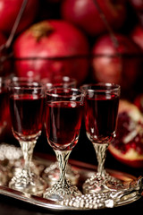 Still life on a dark background. Wine (liquor) glasses, fruits a
