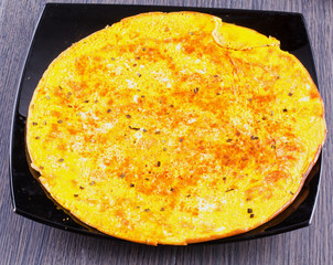 Omelette over black plate