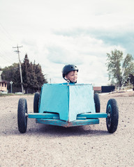 Young boy in a soap-box car