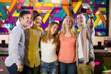 Smiling friends taking a selfie from mobile phone