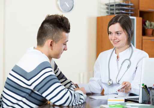 Female Doctor Questioning Teen Patient At Office