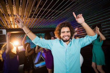 Group of smiling friends dancing on dance floor