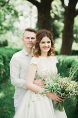 Perfect wedding couple holding luxury bouquet of flowers