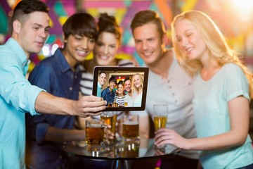 Group of friends clicking a photo from digital tablet