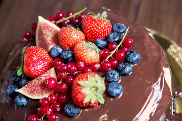 Birthday cake with cream and chocolate, fresh fruit and berries slide.