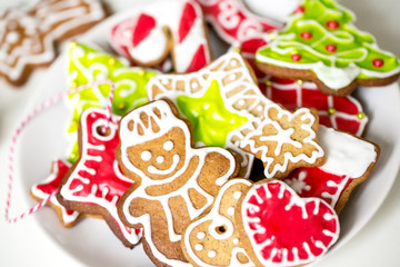 Different Christmas cookies on a plate on a white background