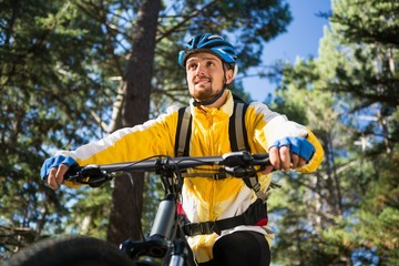 Male mountain biker riding bicycle in the forest