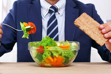 Unrecognizable man has healthy business lunch in modern office