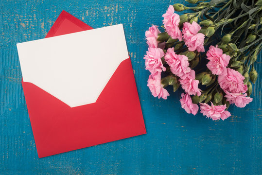 Carnations flowers and envelope on a table
